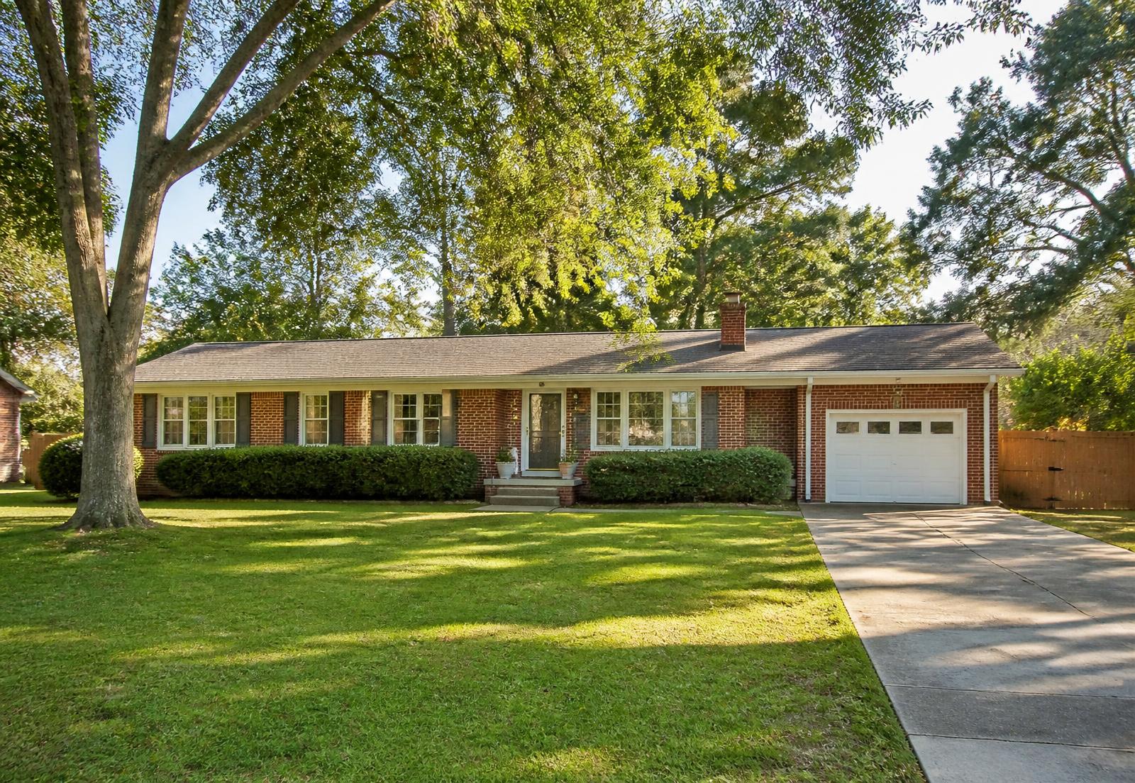Brick ranch-style family home with a green lawn in a North Carolina neighborhood